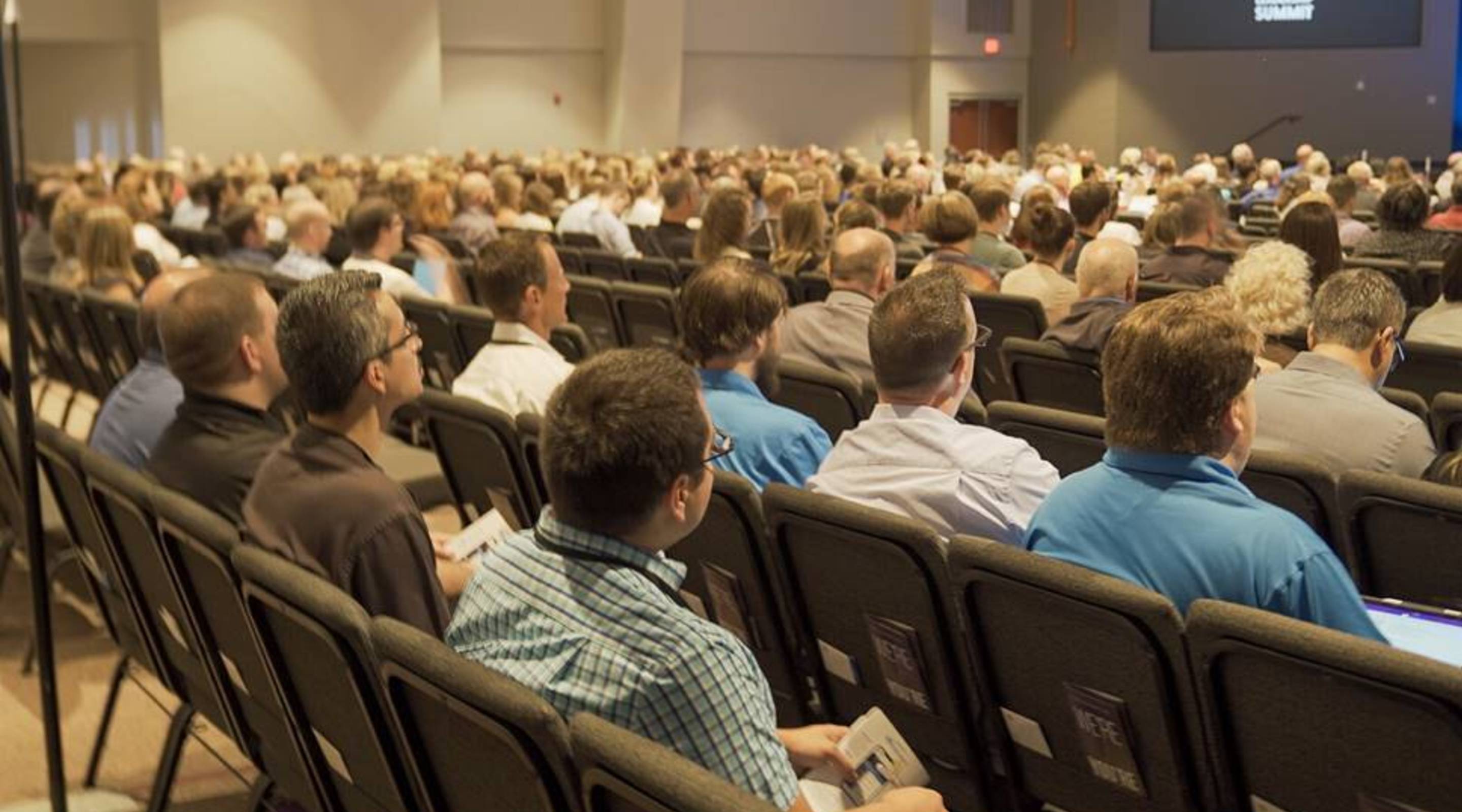 The team seated in the audience at an industry summit keynote