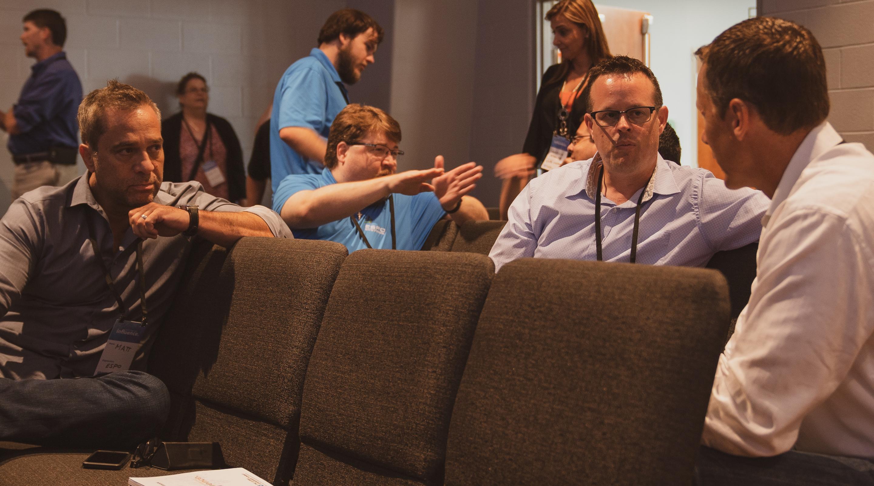 Team members in conversation between conference sessions